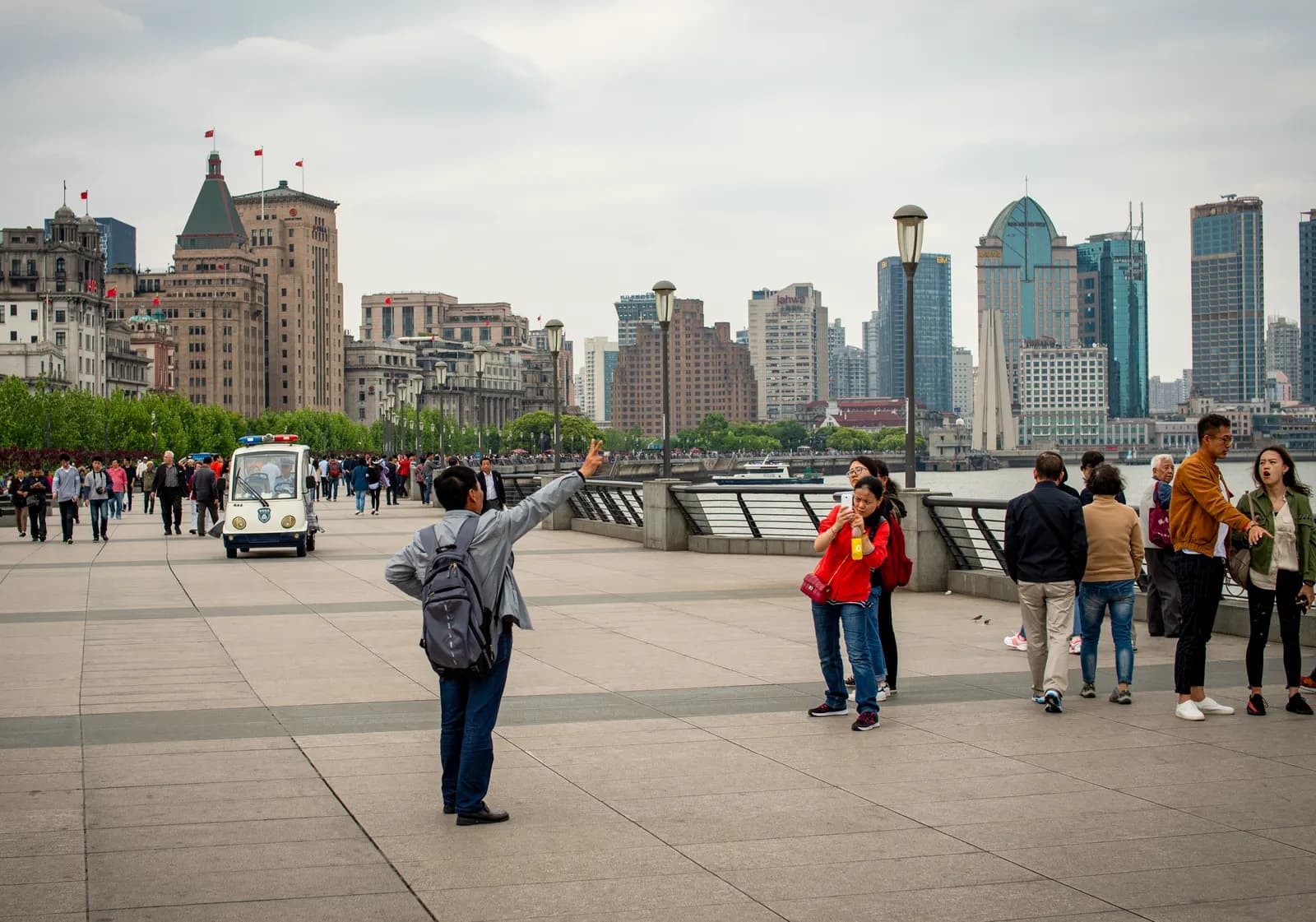 Travellers on The Bund with Shanghai's skyline in the distance